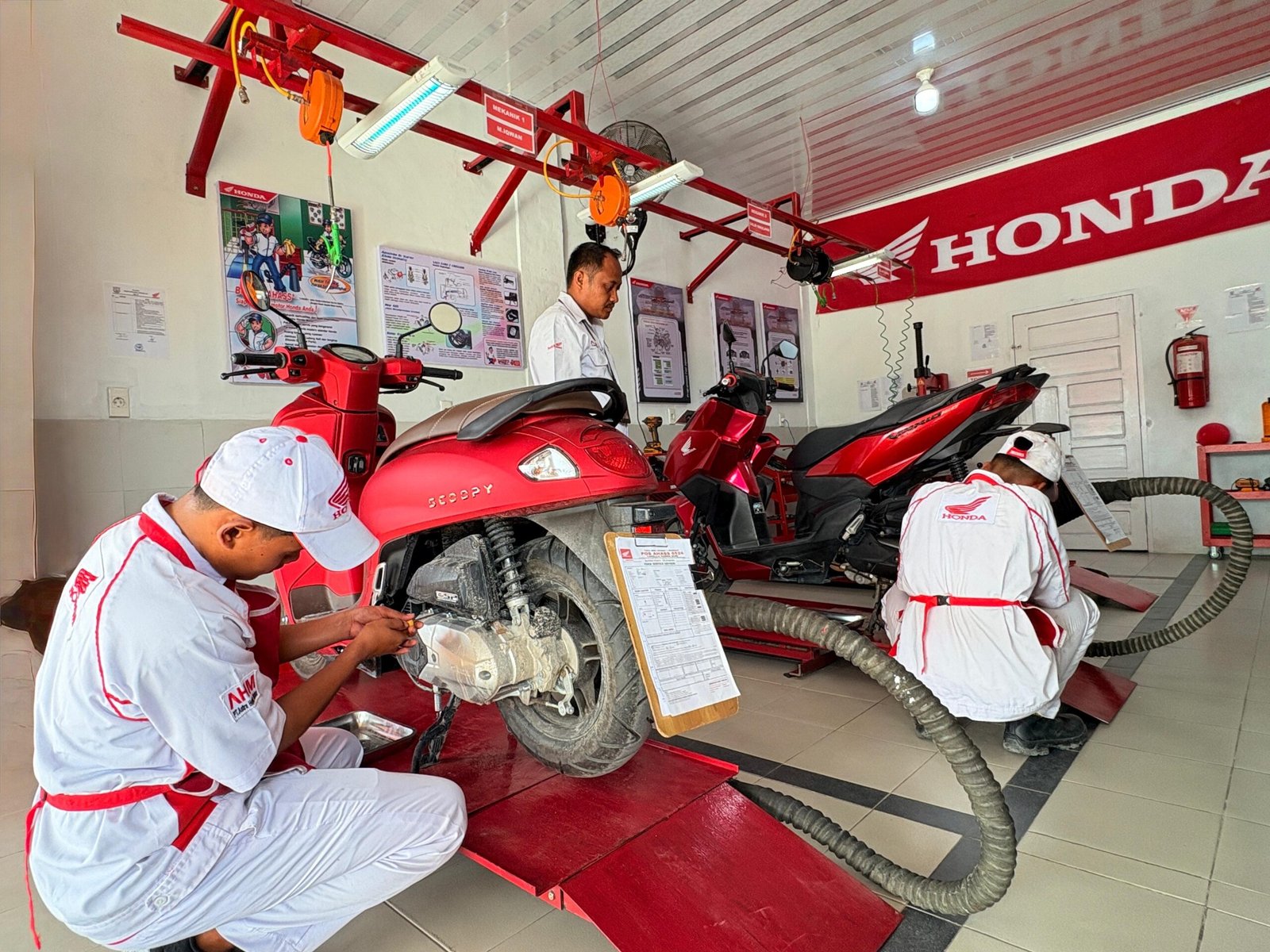 Para siswa SMK Negeri 3 Mandau sedang melakukan perawatan sepeda motor konsumen di fasilitas Pos AHASS TEFA yang diawasi langsung oleh teknisi ahli dari AHASS Capella Service Center (CSC) Duri.